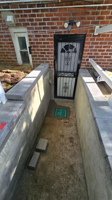 Concrete retaining walls with caps at a basement entrance before the floor pour