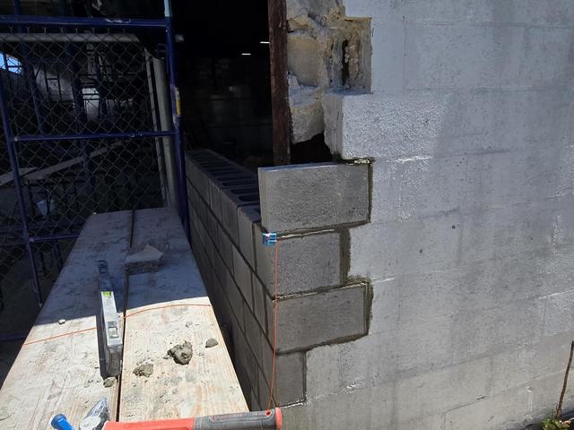 New concrete block tied into an existing wall during reconstruction