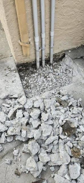 Broken concrete rubble removed from beside a building during a repair