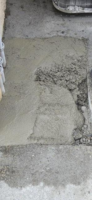Close-up of a deteriorated, patched concrete surface before replacement
