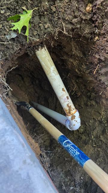 Trench dug for a PVC drain line along a foundation wall