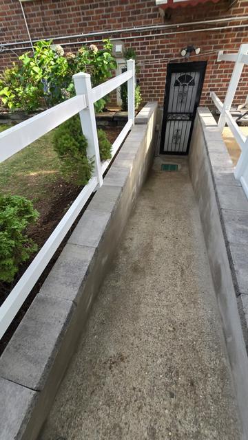 Finished concrete basement entrance with capped retaining walls
