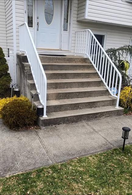 Front stoop steps with railings leading up to a home entry