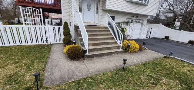 Front yard of a home with a new paver walkway and stone work leading to the entry