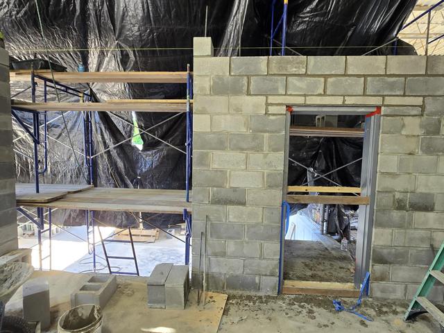 New concrete block wall with a framed door opening and steel lintel