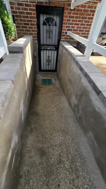 Smooth parged concrete walls and new floor at a basement entrance