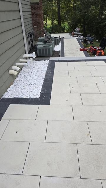 Full-length view of a porcelain side walkway with white stone edging and a dark border