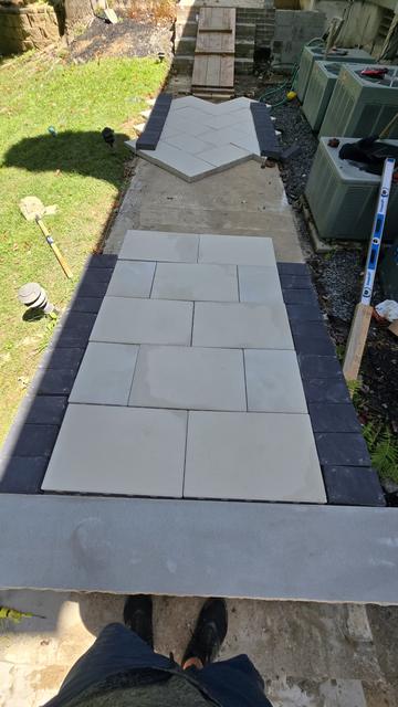 Porcelain walkway with a dark border leading to steps, viewed from above