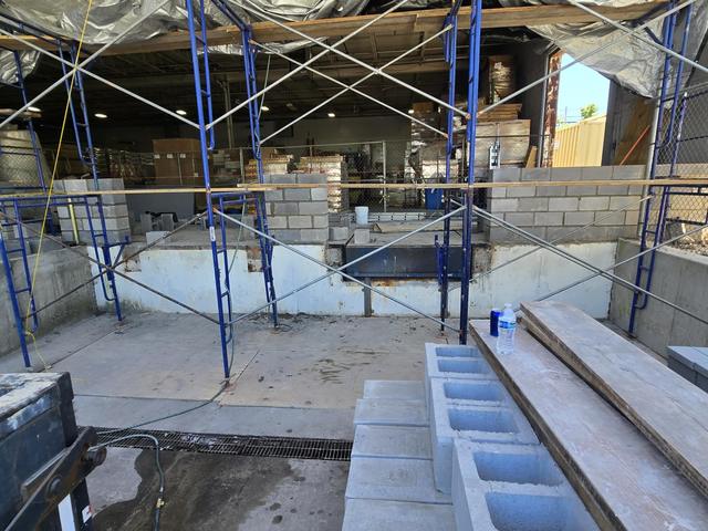 Scaffolding set up and new concrete block staged for a wall reconstruction
